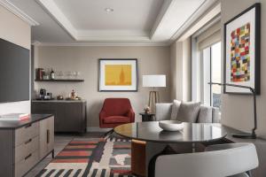 a living room with a table and a red chair at Four Seasons Hotel San Francisco at Embarcadero in San Francisco