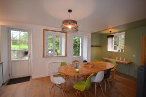 a dining room with a wooden table and chairs at L'Escale du Bocage Piscine couverte chauffée in La Flocellière