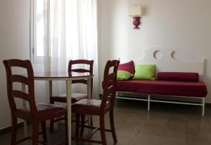a living room with a couch and a table and chairs at Hotel O'scià in Lampedusa