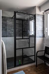 La salle de bains est pourvue d'une douche avec une porte en verre. dans l'établissement Appartement vue panoramique mer, prêt de vélos, WIFI, à Quiberon