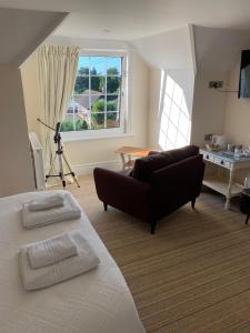 a living room with a bed and a couch at Devonia Guest House in Lyme Regis