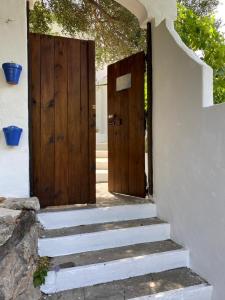 two wooden doors on the side of a building with stairs at El nido de aguila in Casares