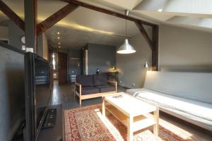 a living room with a bed and a couch and a table at Klimatyczne poddasze in Przemyśl +9 photos