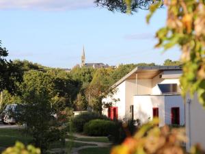 une maison blanche avec des portes rouges dans une cour dans l'établissement Gîtes & Tiny houses Les Hauts de Toulvern, à Baden