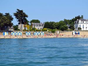 una spiaggia con ombrelloni e persone di Gîtes & Tiny houses Les Hauts de Toulvern a Baden