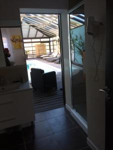 a bathroom with a sliding glass door leading to a pool at Chambre d'hôtes Les Nymphéas in Wimereux