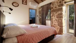 ein Schlafzimmer mit einem Bett und einer Steinmauer in der Unterkunft Villa HERA in Kornić