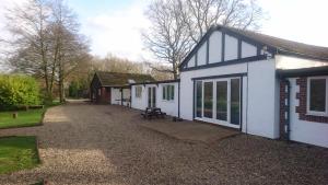 a row of small white buildings with a driveway at X Adventure in Horsford