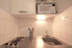 kuchnia ze zlewem i kuchenką mikrofalową w obiekcie Les Studiantes - T1 32 m² hypercentre gares/métro w Lille