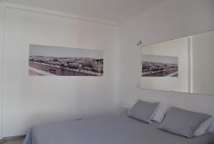 a white bedroom with a bed and a picture on the wall at Casa Amado in Lagos