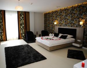 a bedroom with a large bed and two chairs at MELISS EVENTS in Craiova