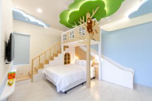 una camera da letto per bambini con un murale sull'albero sul soffitto di The Lin Inn a Kenting