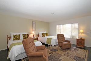 1 dormitorio con 2 camas y 1 silla en Lido Palms Resort & Spa, en Desert Hot Springs
