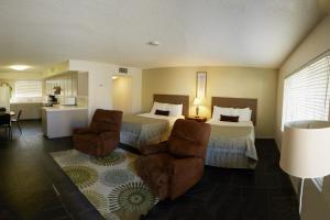 um quarto de hotel com duas camas e duas cadeiras em Lido Palms Resort & Spa em Desert Hot Springs