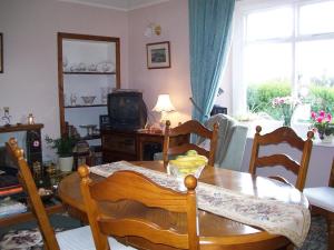 uma sala de estar com uma mesa e cadeiras e uma televisão em Lily Hill Farm em Barnard Castle