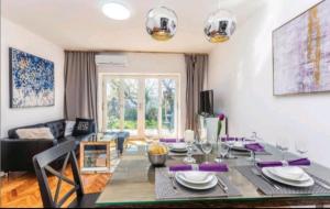 a living room with a dining room table and a couch at Villa deluxe "H" - private jacuzzi in Novi Vinodolski