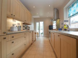 a large kitchen with wooden cabinets and a tile floor at Lime House in Newark-on-Trent