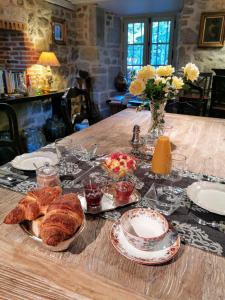 a table with croissants and other food on it at Château de Crocq - Chambres d'Hôtes de Charme in Crocq