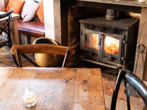 a wood burning stove in a room with a table at The Lion Pub & Grill in Sowerby Bridge