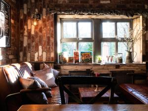 a room with a couch and a table and a window at The Lion Pub & Grill in Sowerby Bridge