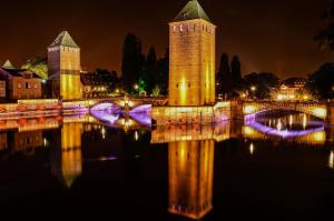 un puente sobre un cuerpo de agua por la noche en The Little Studio, en Estrasburgo