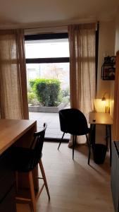 a living room with a table and chairs and a window at The Little Studio in Strasbourg