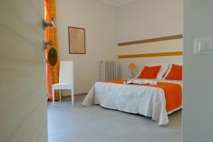 a bedroom with a bed with orange sheets and a chair at BNB Airone in Sommariva Perno
