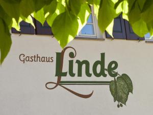 a sign on the side of a building with green leaves at Gasthaus Linde in Hofstetten