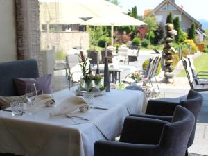 Hofstetten的住宿－Gasthaus Linde，庭院里配有带白色桌布和椅子的桌子