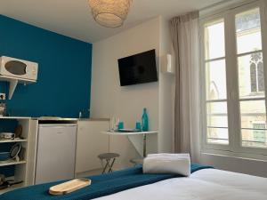 1 dormitorio con cama y pared azul en Logis St Joseph en Angers