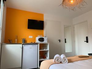 a kitchen with a refrigerator and a microwave at Logis St Joseph in Angers