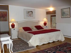 Saint-ThoméにあるLe Moulinageのベッドルーム1室(ベッド1台、テーブル2台、ランプ2つ付)