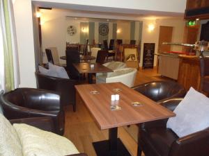 a restaurant with wooden tables and leather chairs at The London Inn in Cheltenham