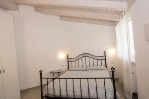 a bedroom with a black bed in a white room at Appartamenti Laly in Arco