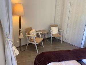 Zimmer mit 2 Stühlen, einem Tisch und einer Lampe in der Unterkunft La Bergerie in Le Pouliguen