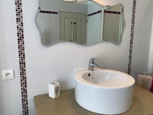 un bagno con lavandino e specchio di La Bergerie a Le Pouliguen Altre 8 foto