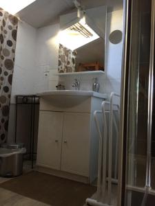een badkamer met een wastafel en een spiegel bij Accacia Home in Ferrières