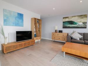 a living room with a flat screen tv and a couch at The Lookout in Newquay