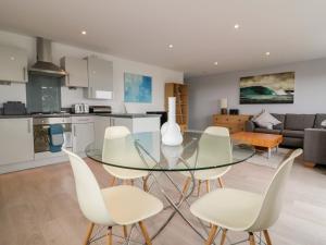 a kitchen and living room with a glass table and chairs at The Lookout in Newquay