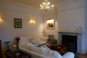 a living room with a white couch and a fireplace at Kerrington House in Axminster