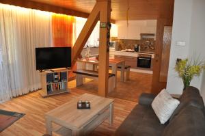 een woonkamer met een bank en een tv en een keuken bij Rentrisch am Waldrand in Sankt Ingbert
