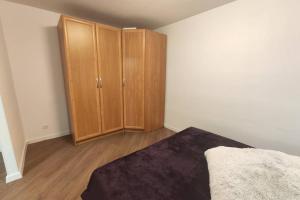 a bedroom with a bed and a wooden cabinet at Cozy stay in unique town - Kėdainiai in Kėdainiai