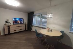 ein Wohnzimmer mit einem Tisch und einem TV in der Unterkunft Cozy stay in unique town - Kėdainiai in Kėdainiai