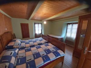 2 bedden in een kamer met houten plafonds bij Tepilanti in Cerentino