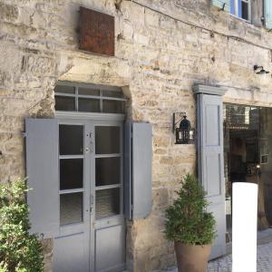 un edificio de piedra con puerta y ventana en Maison Anila en Barjac