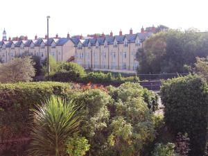 a large building with a lot of bushes and flowers at Maison in Bushmills