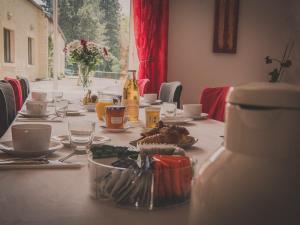 una mesa con platos de comida y una botella de vino en La Maison Periot, en Trévières