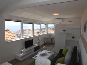 a living room with a couch and a tv at Villa Green Panorama in Dubrovnik