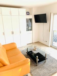 ein Wohnzimmer mit einem Sofa und einem Couchtisch in der Unterkunft Ferienwohnung Spatzennest in Kronau
