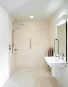 a white bathroom with a sink and a shower at Manor Farm Courtyard Cottages in Hampstead Norris